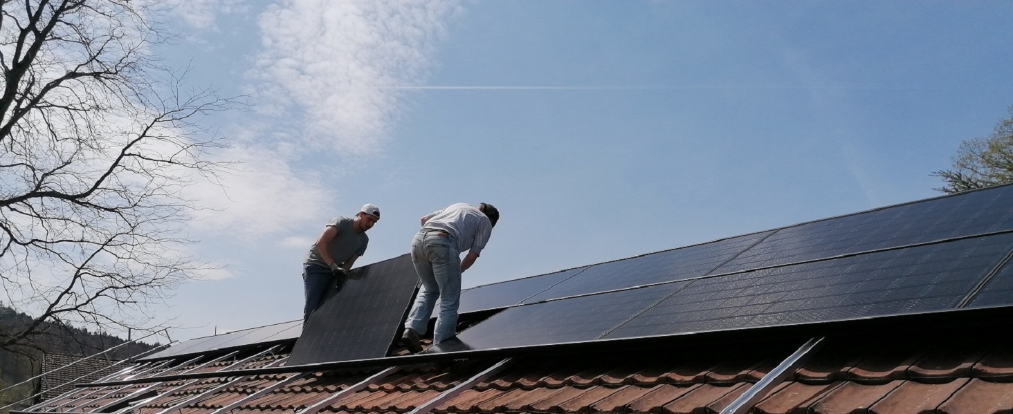 Vier Personen auf Dach mit Solarpanel